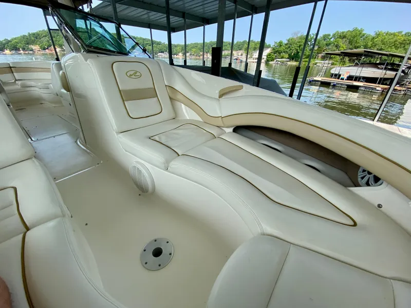 Slide: The Image of 2001 Sea Ray 290 Bowrider with luxurious white seating, docked by a scenic lake. - 25