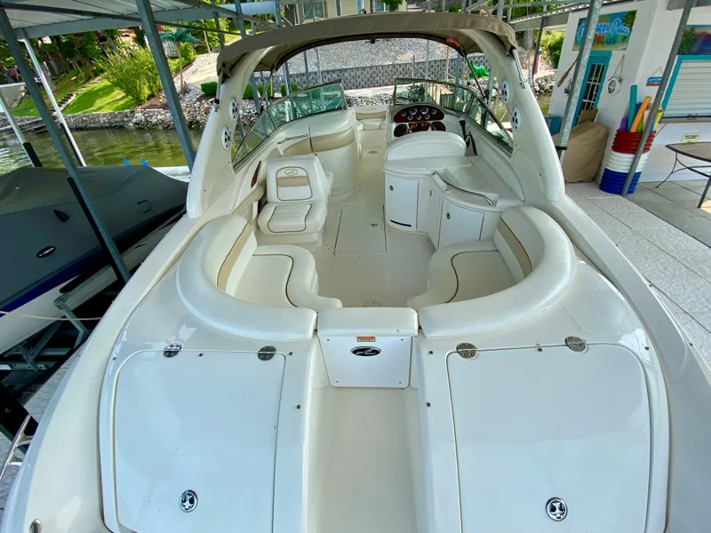 Slide: The Image of 2001 Sea Ray 290 Bowrider with spacious seating and sleek design in a marina setting. - 32