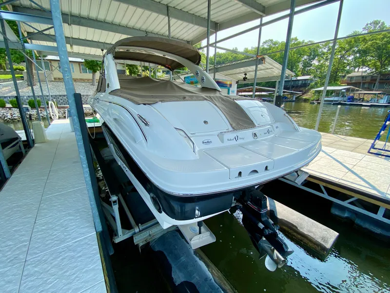 Slide: The Image of 2001 Sea Ray 290 Bowrider docked under a covered marina, rear view. - 4