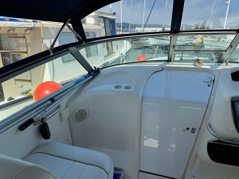 Slide: The Image of 1997 Sea Ray 330 Sundancer cockpit with marina view, featuring sleek design and comfortable seating. - 10