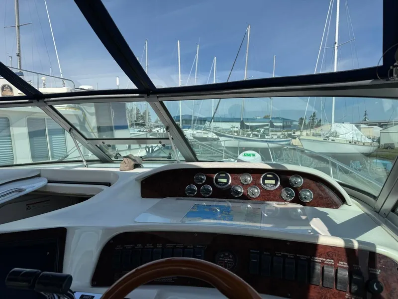 Slide: The Image of 1997 Sea Ray 330 Sundancer cockpit with marina view, showcasing dashboard and controls. - 12