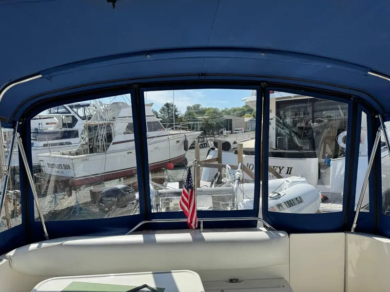 Slide: The Image of 1997 Sea Ray 330 Sundancer interior view with marina backdrop and American flag. - 17