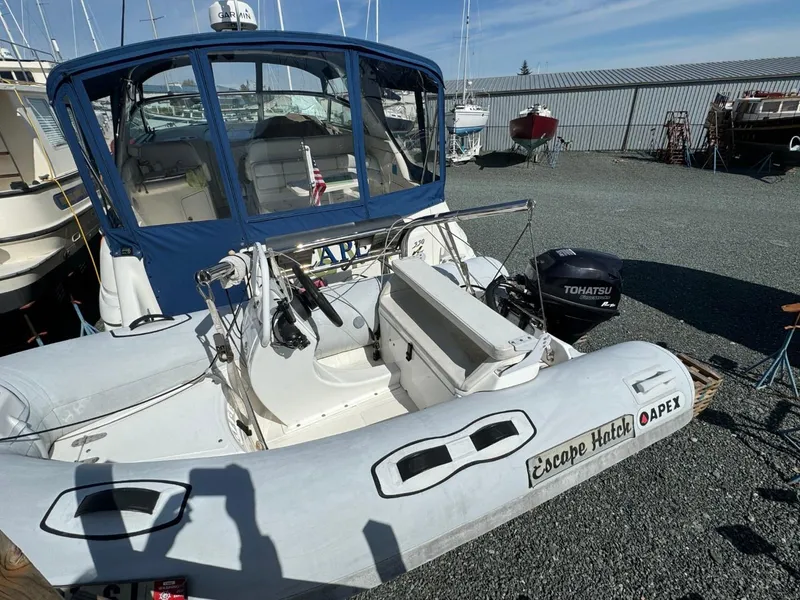 Slide: The Image of 1997 Sea Ray 330 Sundancer with Apex inflatable boat, docked in a marina. - 2