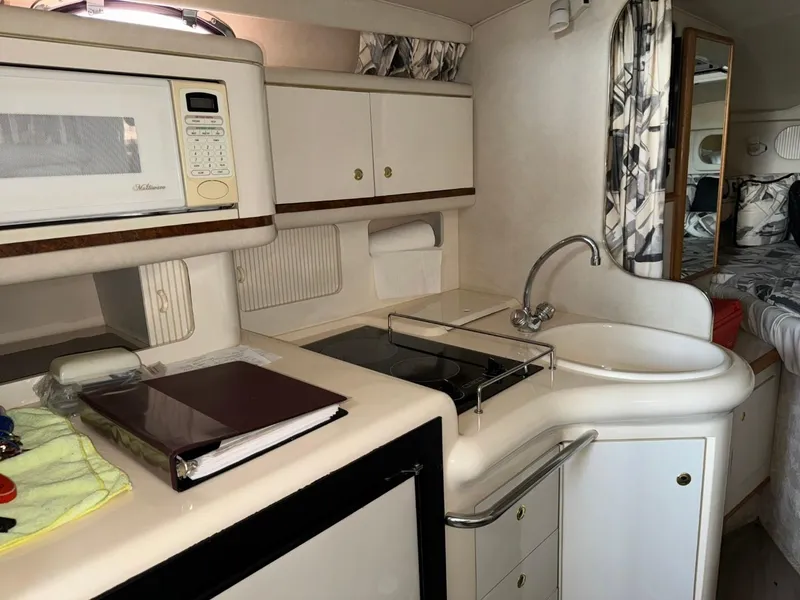 Slide: The Image of 1997 Sea Ray 330 Sundancer kitchen with microwave, sink, and stove. - 20