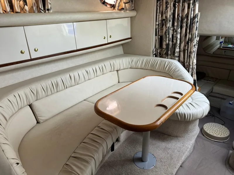 Slide: The Image of Interior of 1997 Sea Ray 330 Sundancer with cream seating and wooden table. - 25