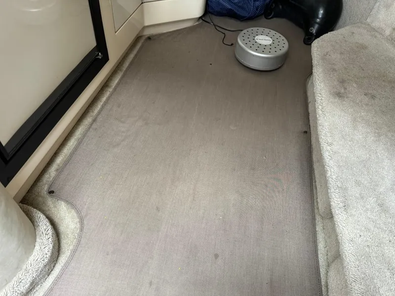 Slide: The Image of Interior view of a 1997 Sea Ray 330 Sundancer boat with carpeted flooring. - 28