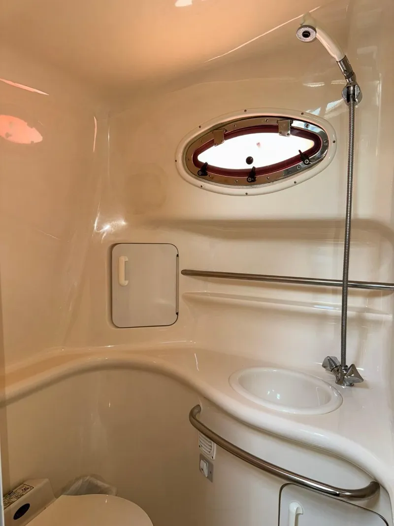 Slide: The Image of 1997 Sea Ray 330 Sundancer bathroom with sink, shower, and porthole window. - 29