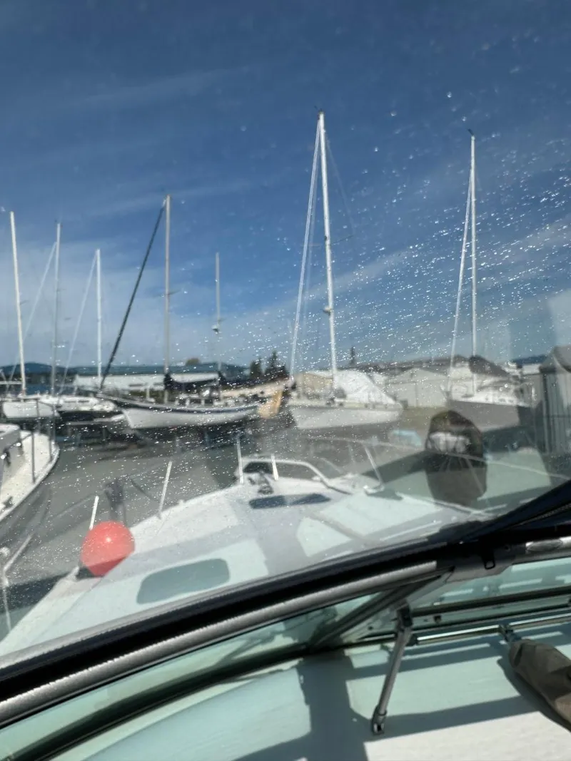 Slide: The Image of 1997 Sea Ray 330 Sundancer docked at marina with sailboats in background. - 32