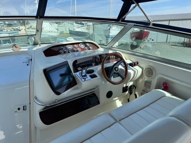 Slide: The Image of 1997 Sea Ray 330 Sundancer helm with steering wheel, gauges, and navigation equipment. - 9