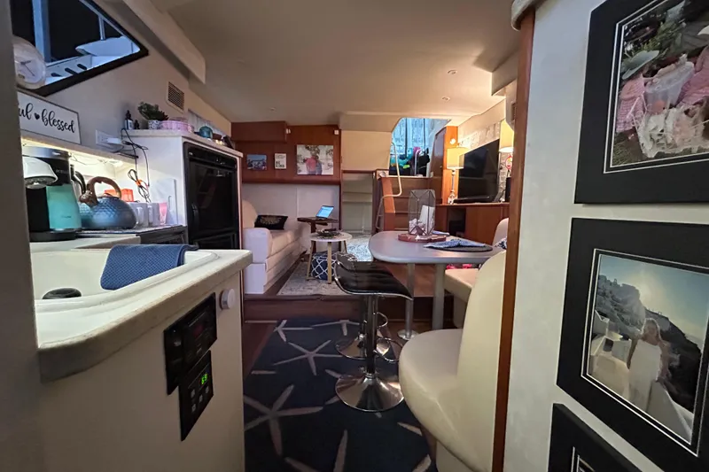 Slide: The Image of Interior of a 1999 Silverton 352 Motor Yacht, featuring a cozy living area and kitchenette. - 26