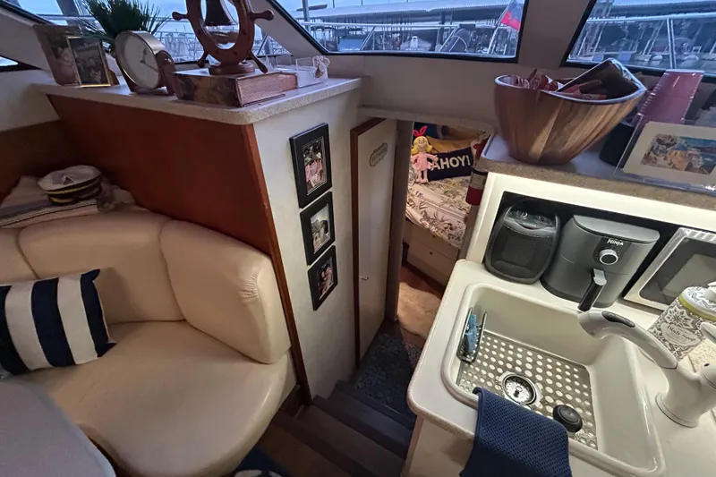 Slide: The Image of Interior of a 1999 Silverton 352 Motor Yacht with cozy seating and kitchenette. - 30