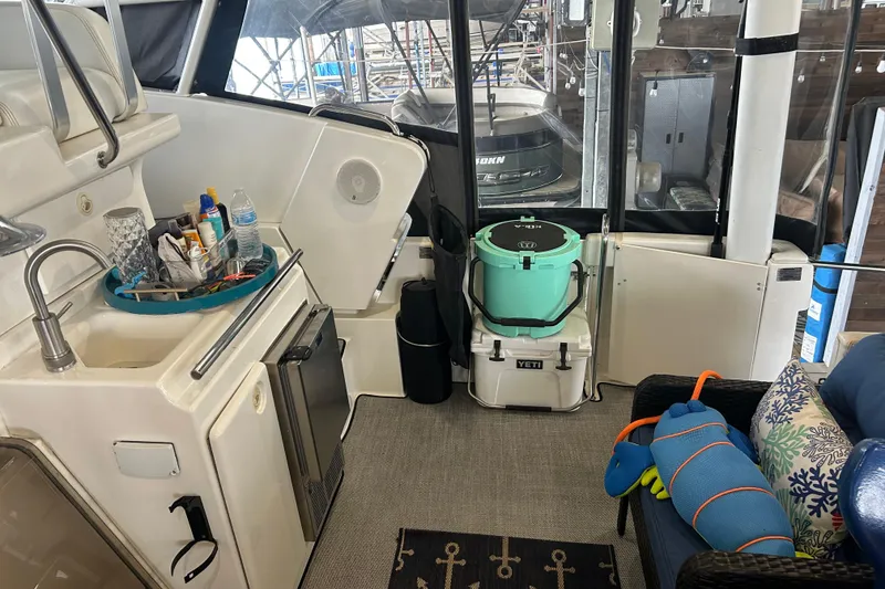 Slide: The Image of 1999 Silverton 352 Motor Yacht interior with kitchenette, Yeti coolers, and seating area. - 42