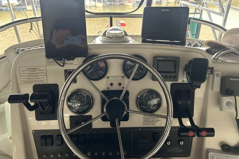 Slide: The Image of 1999 Silverton 352 Motor Yacht helm with gauges, controls, and navigation equipment. - 47