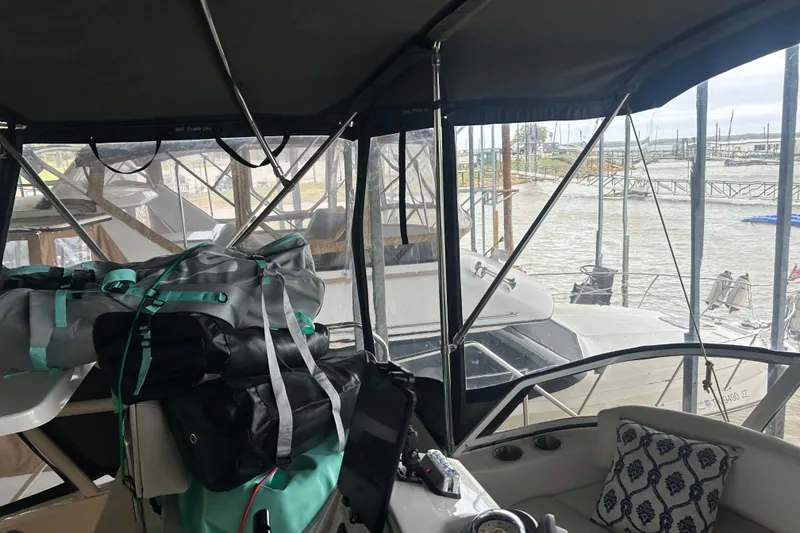 Slide: The Image of Interior view of a 1999 Silverton 352 Motor Yacht with bags and marina backdrop. - 51