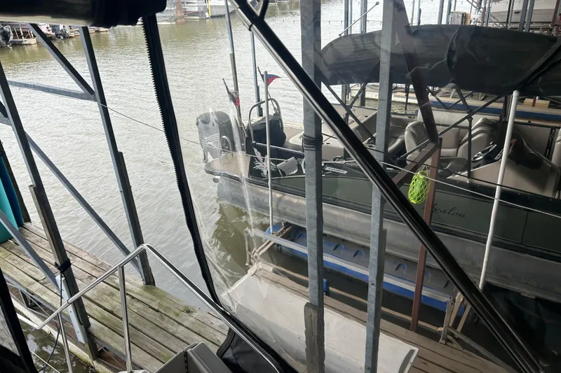 Slide: The Image of 1999 Silverton 352 Motor Yacht docked beside a pontoon boat in a marina. - 53