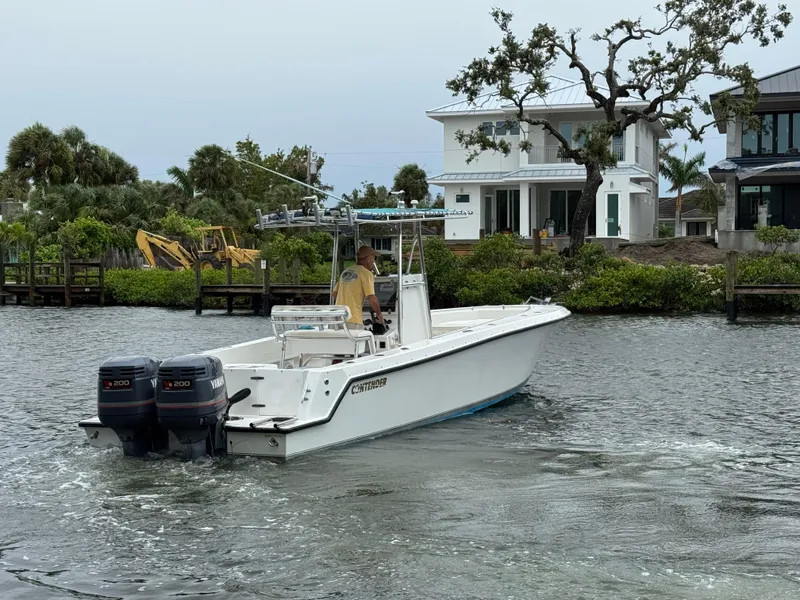 Slide: The Image of 2000 Contender 25 Open boat cruising on a river near waterfront homes. - 9