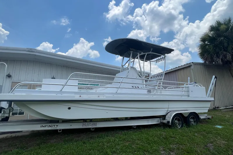 Slide: The Image of 2022 Mirage Bay Cat 26 boat on trailer in front of building. - 3