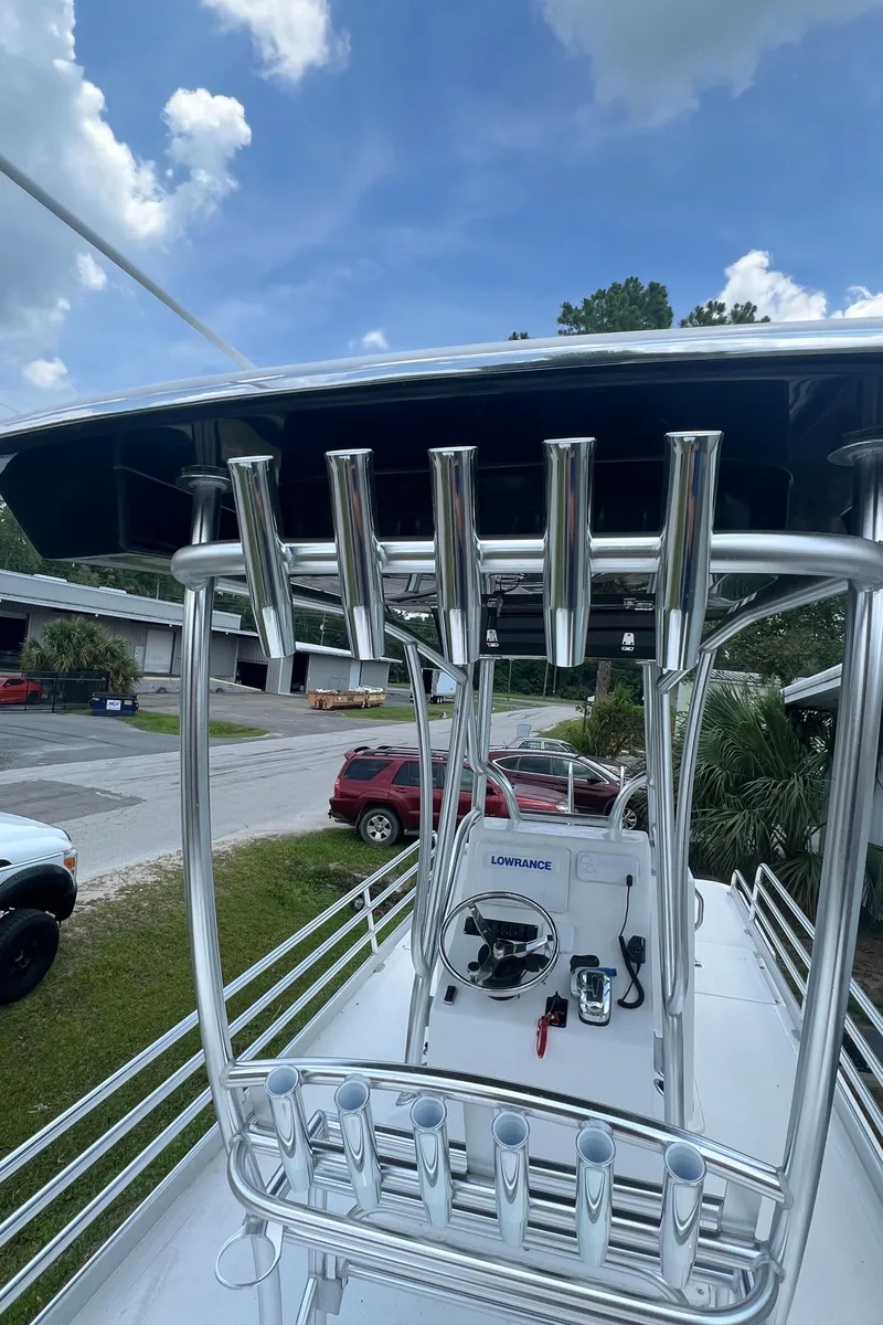 Slide: The Image of 2022 Mirage Bay Cat 26 boat with fishing rod holders and helm console. - 6