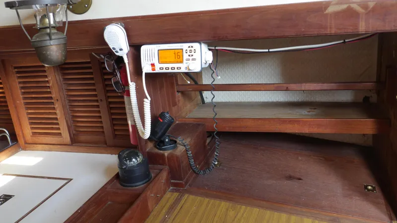 Slide: The Image of 1979 Tayana 37 interior with radio, compass, and wooden shelves. - 24