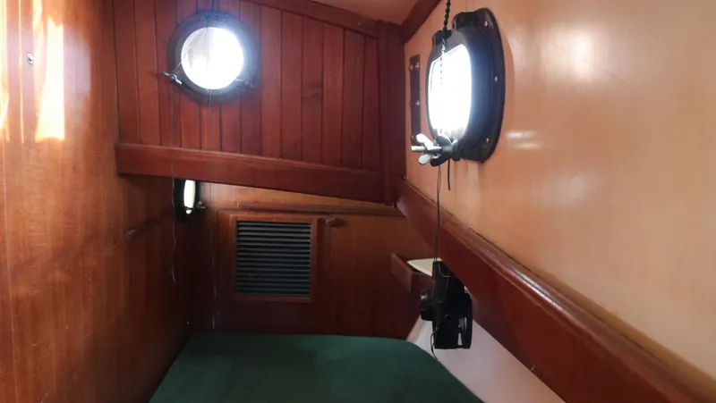 Slide: The Image of 1979 Tayana 37 cabin interior with wooden paneling and portholes. - 46