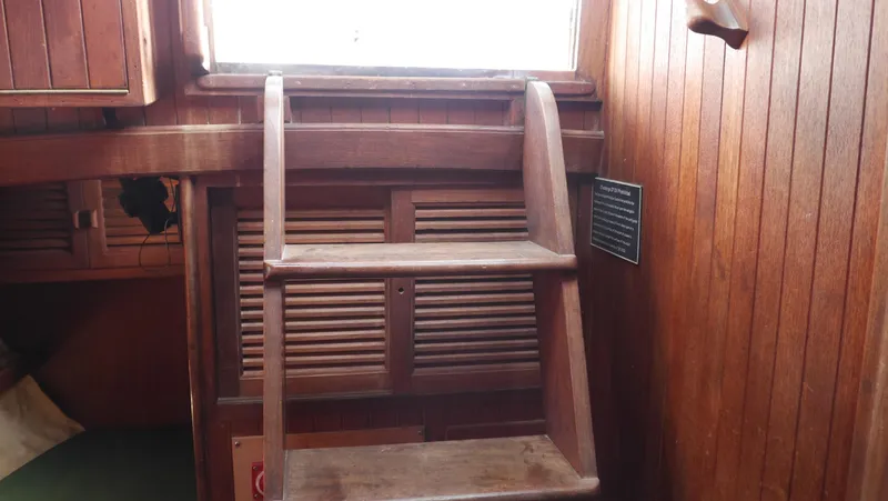Slide: The Image of Wooden interior of 1979 Tayana 37 sailboat with ladder and storage compartments. - 22