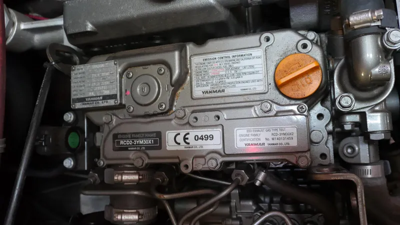 Slide: The Image of Engine compartment of a 1979 Tayana 37 sailboat, featuring Yanmar components and labels. - 30