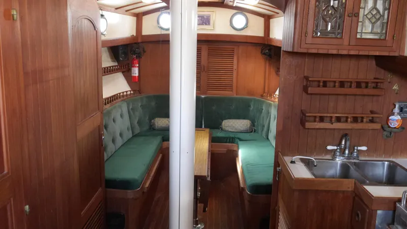 Slide: The Image of Interior of a 1979 Tayana 37 sailboat with wooden furnishings and green seating. - 41