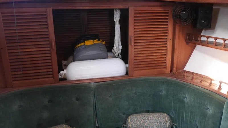 Slide: The Image of 1979 Tayana 37 interior with green seating and wooden storage cabinets. - 40