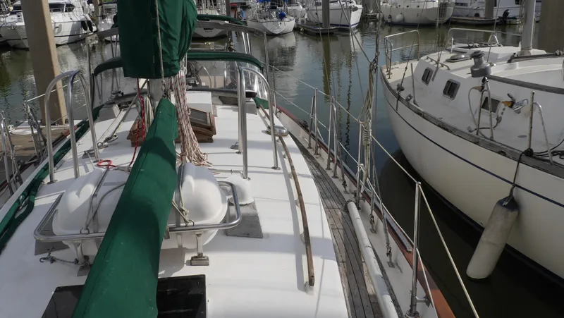 Slide: The Image of 1979 Tayana 37 sailboat docked in a marina, surrounded by other boats. - 16