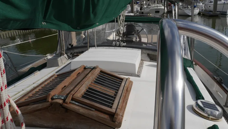 Slide: The Image of 1979 Tayana 37 sailboat deck with wooden hatch and green canopy. - 14