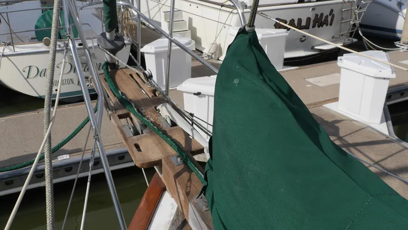 Slide: The Image of 1979 Tayana 37 sailboat docked, featuring green canvas and wooden deck details. - 17