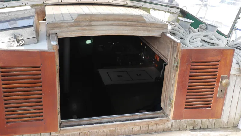 Slide: The Image of Wooden hatch entrance of a 1979 Tayana 37 sailboat, with coiled ropes nearby. - 21