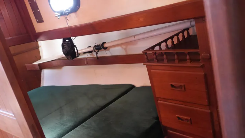 Slide: The Image of Cozy cabin interior of 1979 Tayana 37 sailboat with wooden furniture and green bedding. - 44