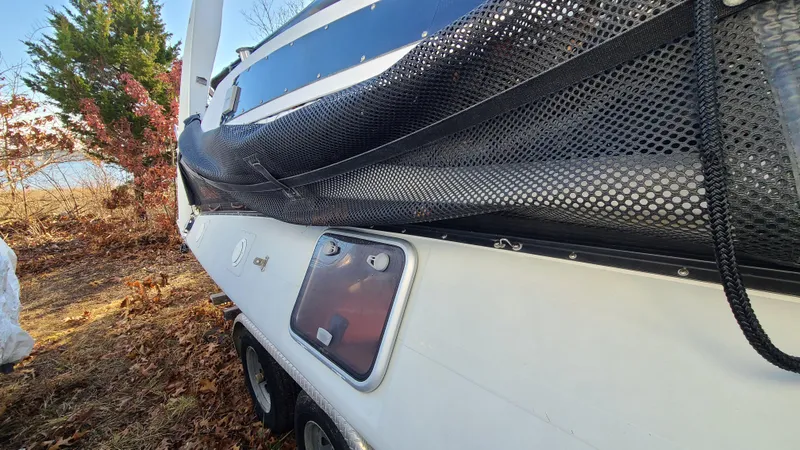 Slide: The Image of 1987 Corsair F-27 sailboat on trailer, side view with netting and hatch, outdoors. - 10