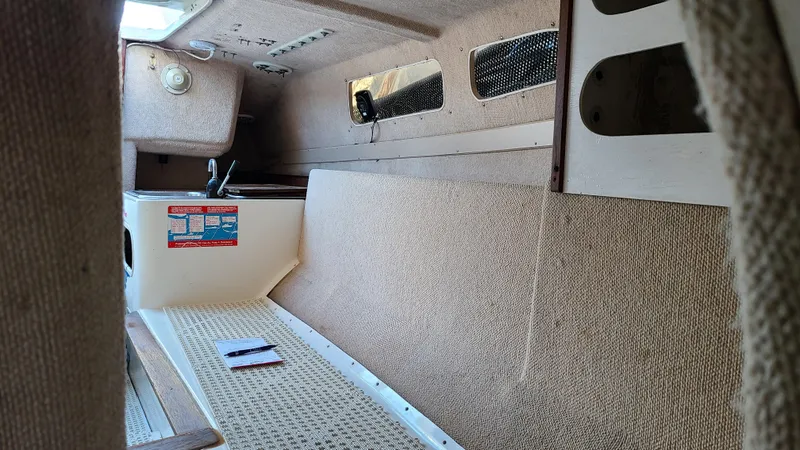 Slide: The Image of Interior of 1987 Corsair F-27 sailboat, featuring compact cabin space and beige upholstery. - 15