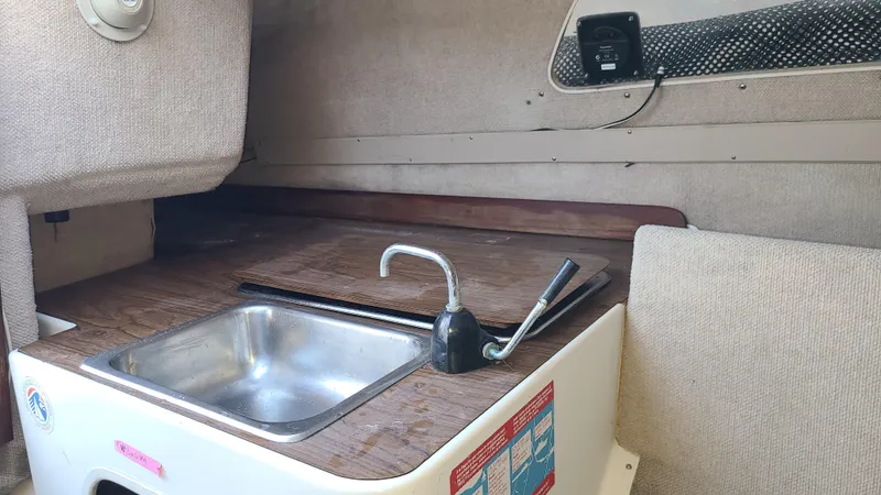 Slide: The Image of Compact kitchen area in a 1987 Corsair F-27 sailboat, featuring a sink and faucet. - 16