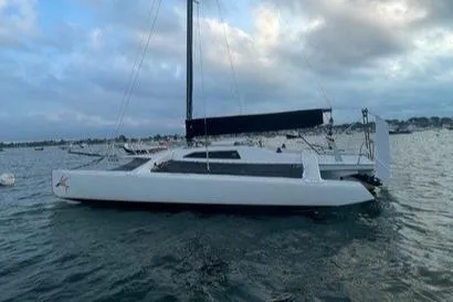 Slide: The Image of 1987 Corsair F-27 trimaran sailboat on calm water under cloudy sky. - 2