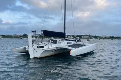 Slide: The Image of 1987 Corsair F-27 trimaran sailboat on calm water under cloudy sky. - 3