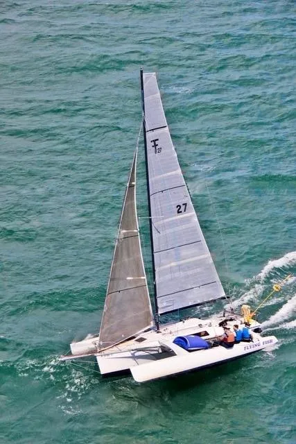 Slide: The Image of Sailing Corsair F-27 trimaran on open water, 1987 model, with visible sails and crew. - 5