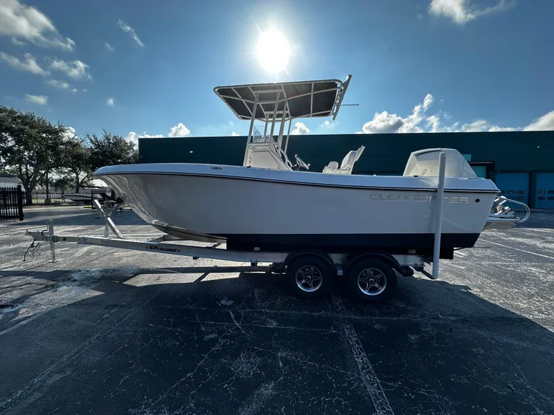 Slide: The Image of 2022 Clearwater 2300 CC boat on trailer under sunny sky. - 2