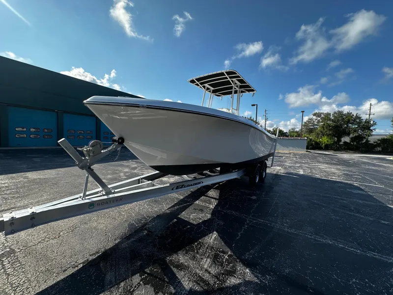 Slide: The Image of 2022 Clearwater 2300 CC boat on trailer under clear blue sky. - 3