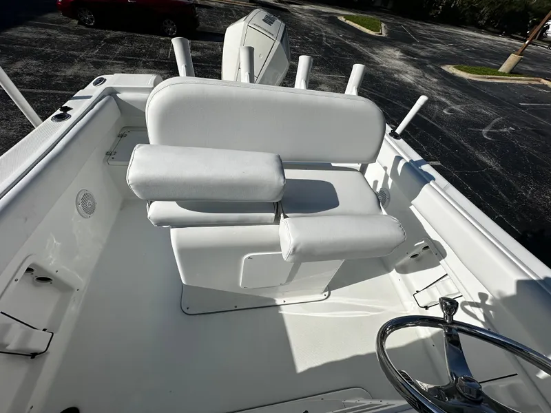 Slide: The Image of 2022 Clearwater 2300 CC boat interior with white seating and steering wheel. - 6