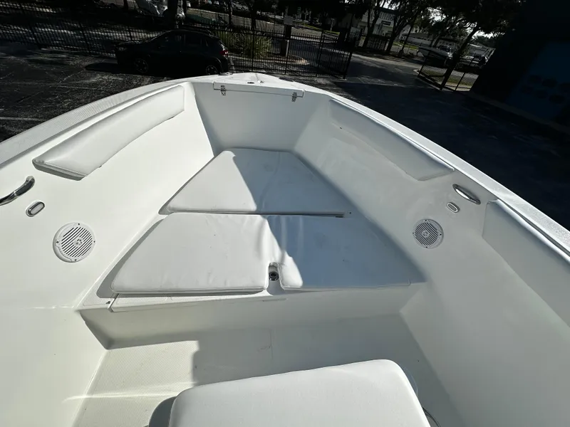 Slide: The Image of 2022 Clearwater 2300 CC boat interior with white cushioned seating and speakers. - 7