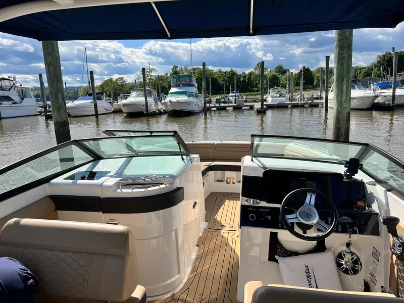 Slide: The Image of 2021 Sea Ray SDX 290 boat interior at marina, showcasing helm and seating area. - 11