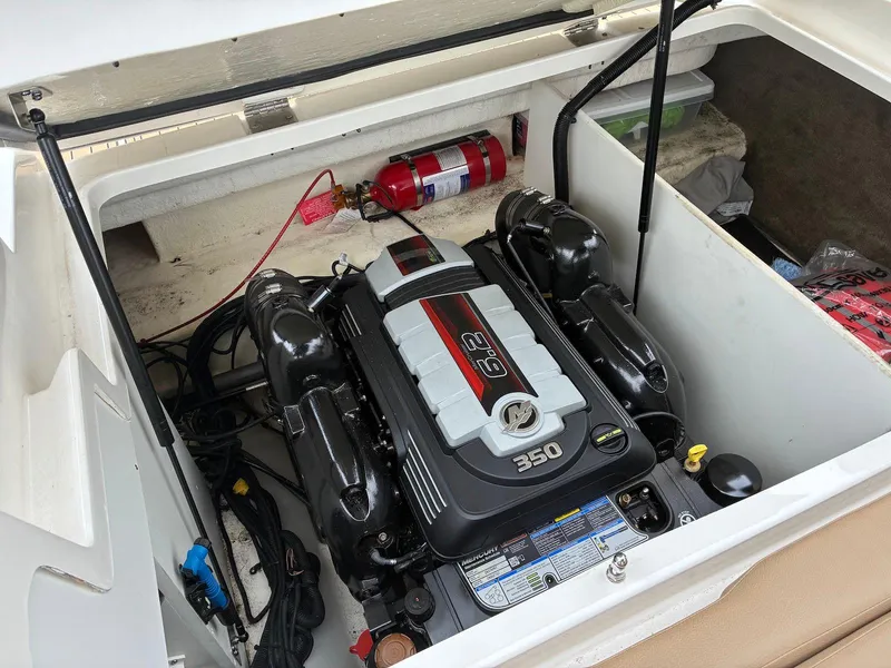 Slide: The Image of 2021 Sea Ray SDX 290 engine compartment with fire extinguisher and storage space. - 14