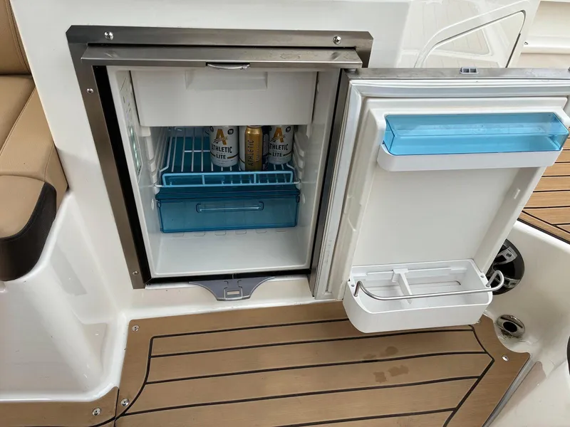 Slide: The Image of Open mini fridge on 2021 Sea Ray SDX 290 boat, stocked with drinks, on teak deck. - 3
