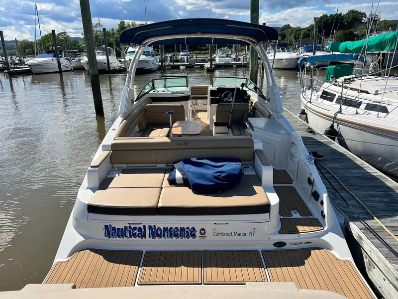 Slide: The Image of 2021 Sea Ray SDX 290 boat docked at a marina, featuring spacious seating and sleek design. - 8
