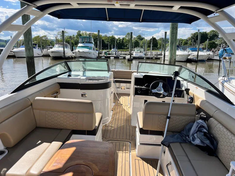 Slide: The Image of 2021 Sea Ray SDX 290 boat interior with tan seating, docked at a marina. - 9