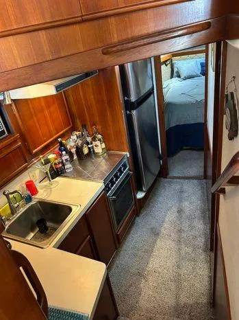 Slide: The Image of 1989 Post 43 Sport Fisherman yacht interior with kitchen, appliances, and cozy bedroom. - 25