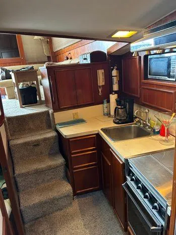 Slide: The Image of 1989 Post 43 Sport Fisherman yacht interior with kitchen, stairs, and wooden cabinetry. - 27